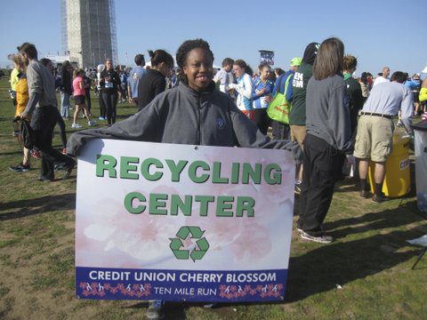 volunteer with recycling sign